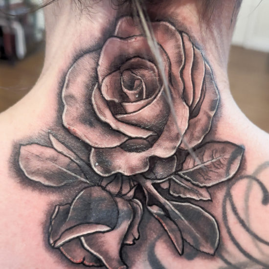 Picture of a realism rose neck tattoo.
