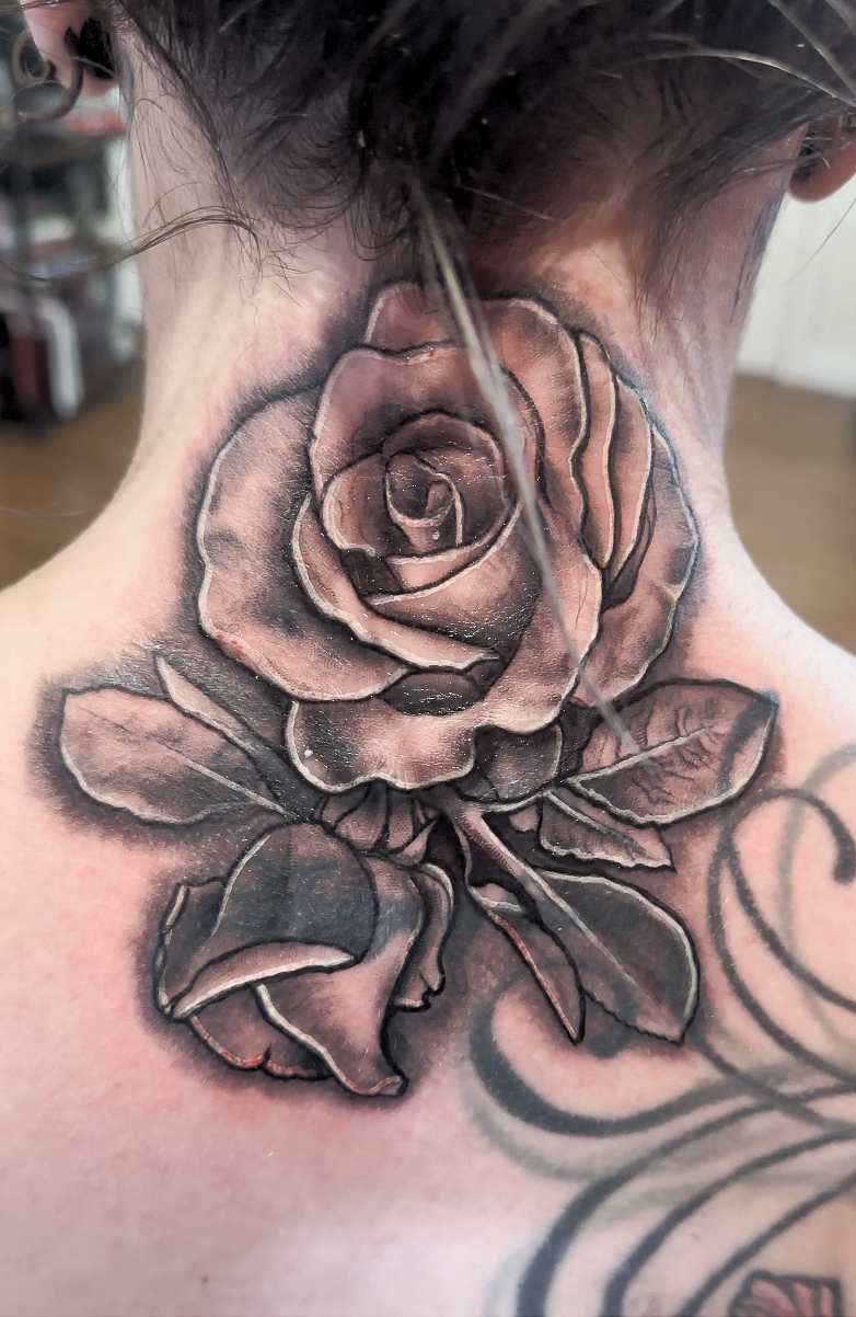 Picture of a realism rose neck tattoo.