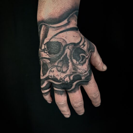 Hand blackwork skull tattoo